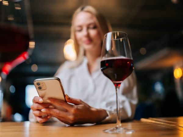 Close-up,Low-angle,View,Of,Pretty,Blonde,Female,Using,Mobile,Phone,